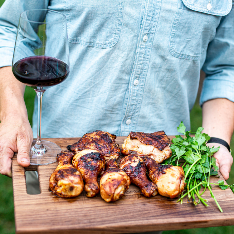 Man with grilled meat and a glass of red wine