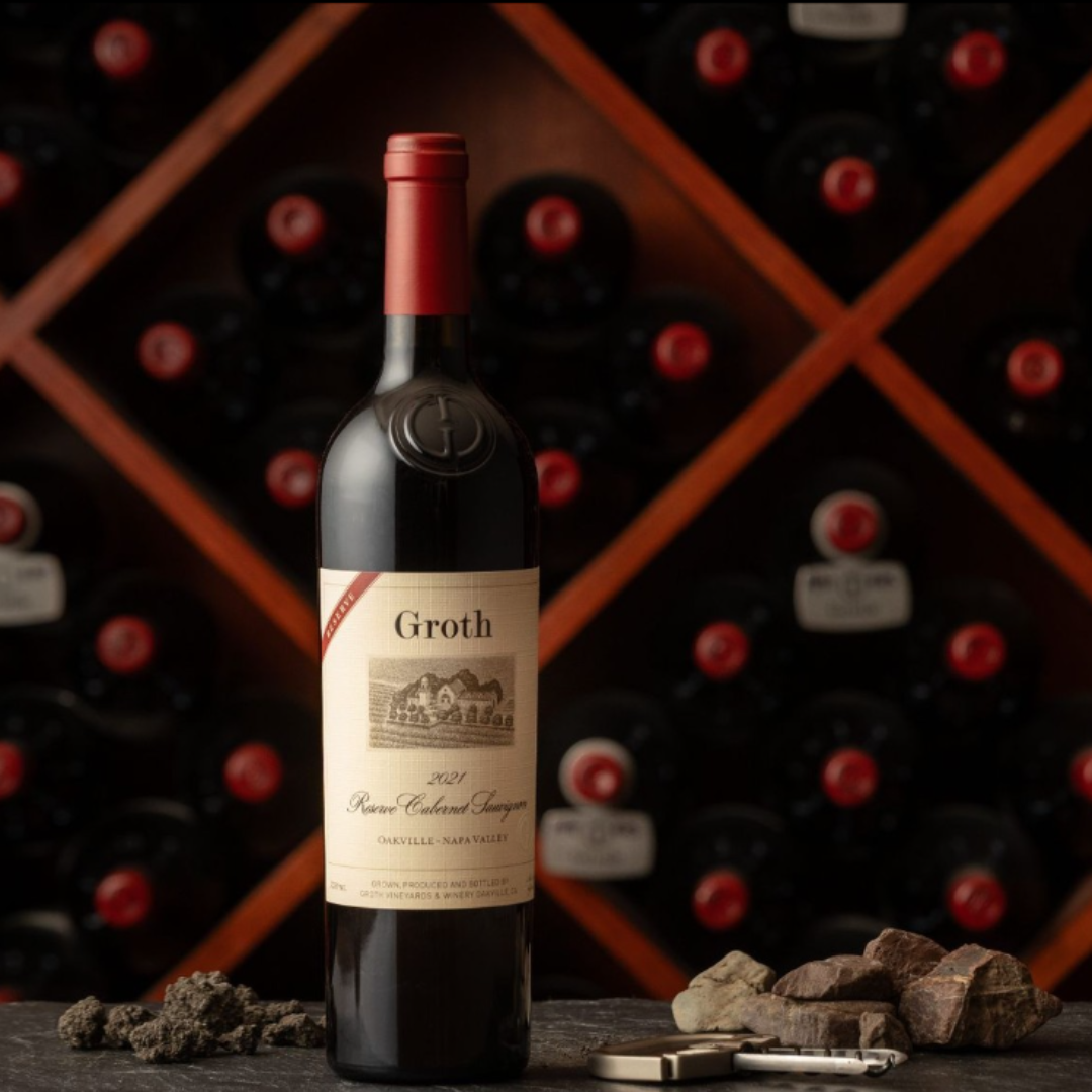 Groth red wine bottle with a wine rack in the background