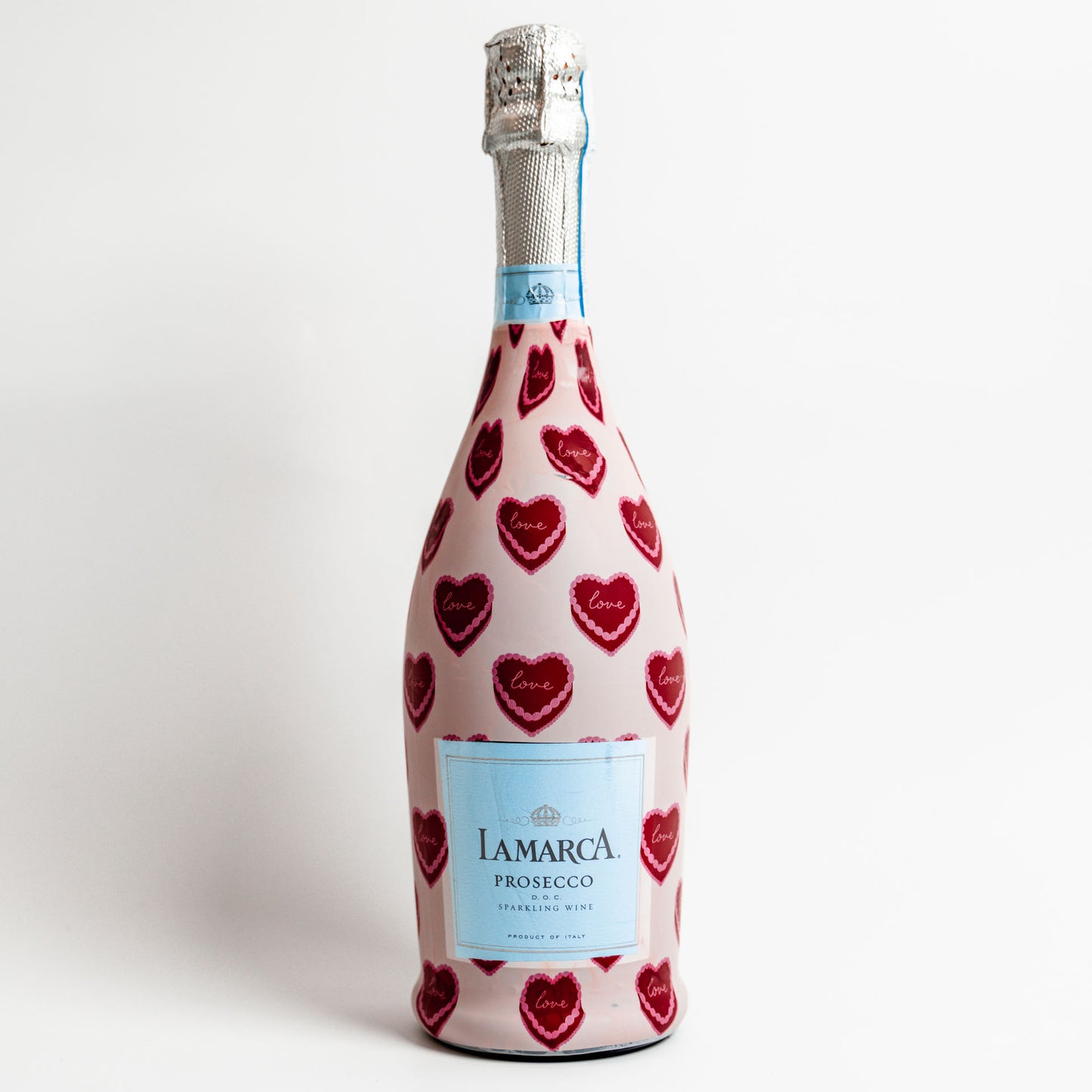 Bottle of Lamarca Prosecco with red heart patterns on a white background
