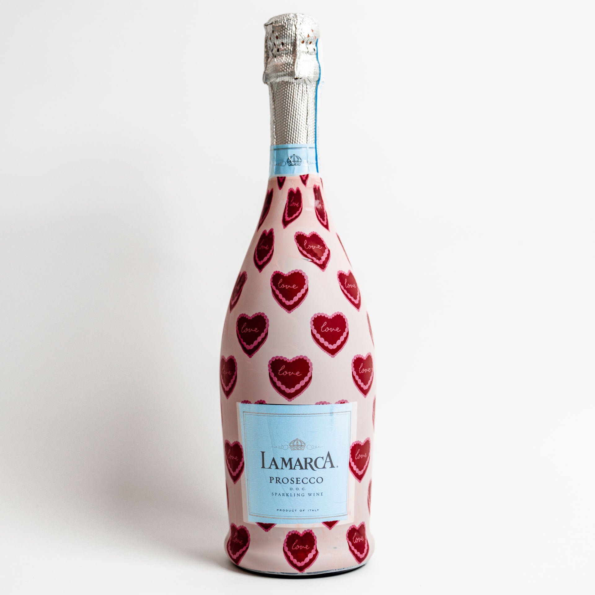 Bottle of Lamarca Prosecco with red heart patterns on a white background