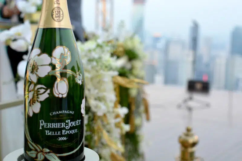 Perrier Jouet Belle Epoque champagne bottle with floral design on a blurred event background