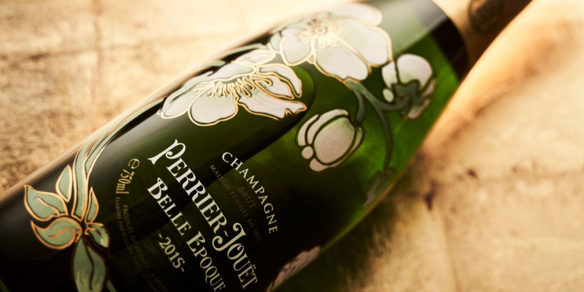 Perrier Joué champagne bottle with floral design on a wooden surface